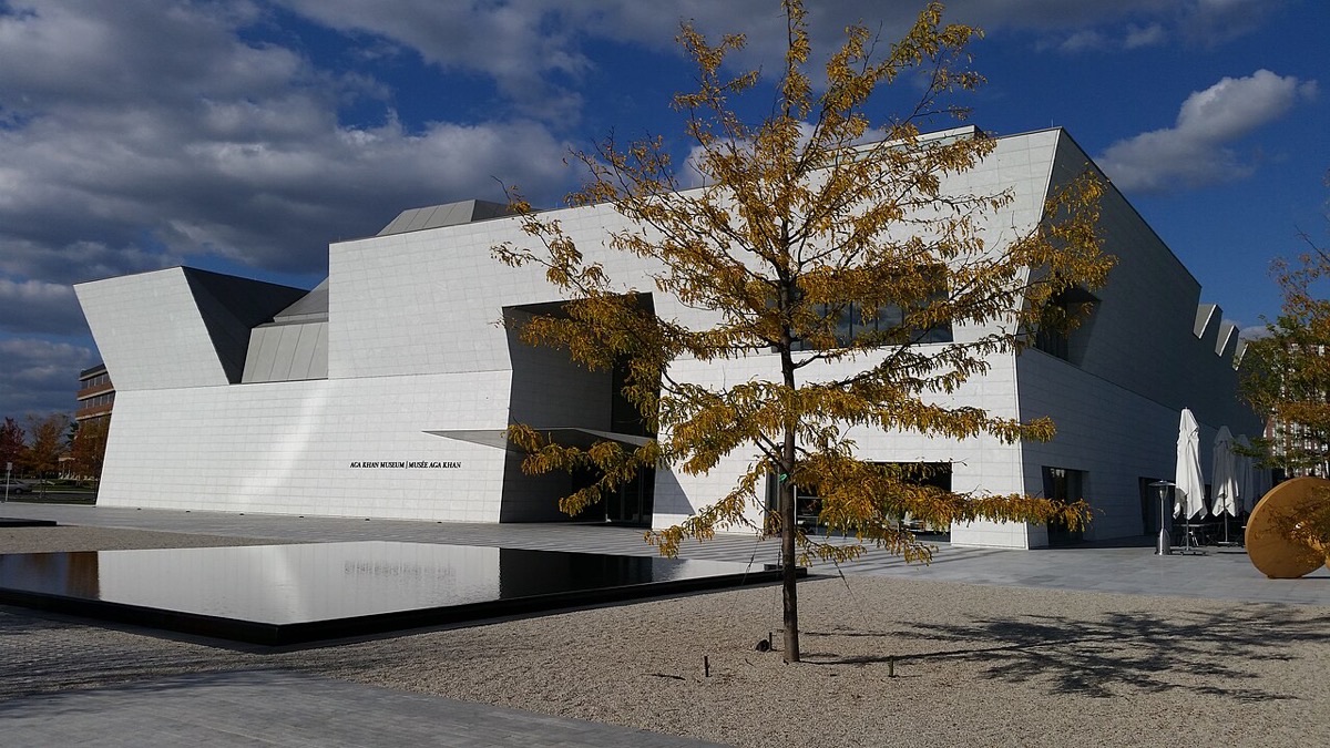 The white geometric facade of the Aga Khan Museum in North York, Toronto, beside its reflecting pool.